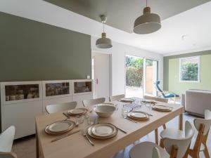 a dining room with a wooden table and chairs at Maison neuve climatisée, 8 pers, proche plages, surf, Wi-Fi, terrasse, parking, ménage inclus - FR-1-319-526 in Biscarrosse +21 photos