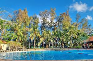 a large swimming pool with palm trees in the background at Sai Gon Can Gio Resort in Cần Giờ