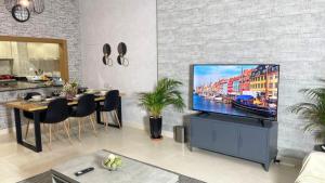 a living room with a flat screen tv on a brick wall at Yas Amazon - Stylish 1BR Apartment on Yas Island, Near Yas Mall in Abu Dhabi