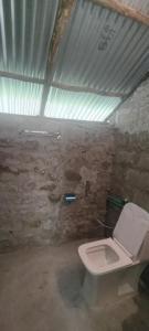 a bathroom with a white toilet in a building at muay monk hostel in Vashisht