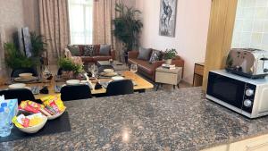 a kitchen and living room with a table and a microwave at Yas Amazon - Stylish 1BR Apartment on Yas Island, Near Yas Mall in Abu Dhabi