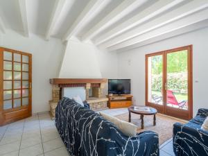un soggiorno con un divano e una TV di Maison au bord du lac de Biscarrosse - 6 pers - Jardin et parking - Proche pistes cyclables - FR-1-319-511 a Biscarrosse