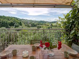 un tavolo in legno con fiori in cima a un balcone di Appartement T2 avec terrasse, parking et wifi à St-Genest-Lerpt - FR-1-496-287 a Saint-Genest-Lerpt