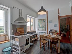 una cucina con un tavolo e una stufa forno superiore di Appartement T2 avec terrasse, parking et wifi à St-Genest-Lerpt - FR-1-496-287 a Saint-Genest-Lerpt