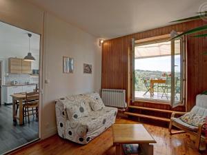 un soggiorno con un divano e un tavolo di Appartement T2 avec terrasse, parking et wifi à St-Genest-Lerpt - FR-1-496-287 a Saint-Genest-Lerpt