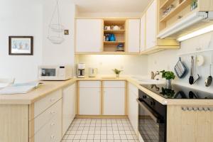 a kitchen with white cabinets and a sink at Waldstraße 2 Kellenhusenliebe in Kellenhusen