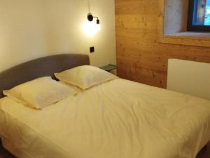 a bed with two pillows on it in a bedroom at Charmant T3 avec Jardin, Parking, et Cuisine Équipée à Saint-Jean-d'Aulps - FR-1-573-130 in Saint-Jean-dʼAulps