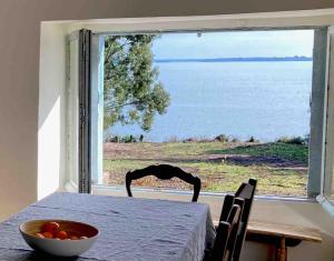 una mesa con un bol de fruta delante de una ventana en Site exceptionnel accès mer grands espaces, en Ile-aux-Moines 49 fotos más