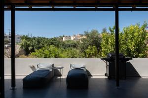 two beds and a table on a balcony at MV Living - Retreat in Daratso +17 photos