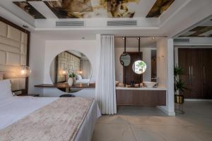 una camera da letto con un letto e un bagno con vasca di King Jason Paphos - Designed for Adults by Louis Hotels a Paphos