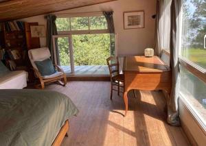 1 dormitorio con escritorio, mesa y ventana en Site exceptionnel accès mer grands espaces, en Ile-aux-Moines