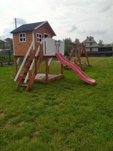 un parque infantil con tobogán y una casa en Domki pod Grapą, en Trybsz
