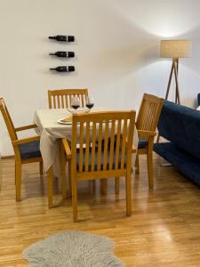 a dining room with a table and chairs and a couch at Cozy Central Apartment in Gjakove