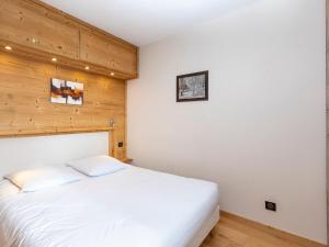 a white bed in a room with wooden walls at Superbe appart rénové, 4 pers, ski aux pieds, balcon sud, wifi inclus - FR-1-314-189 in Avoriaz