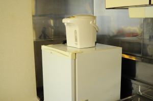 
a white refrigerator freezer sitting on top of a counter at Petit Hotel Koizumi in Lake Toya
