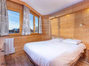 a bedroom with a bed with wooden walls and windows at Charmant Appartement Rénové de 3 Chambres au Centre d'Avoriaz, Proche des Commerces et Pistes - FR-1-314-116 in Avoriaz