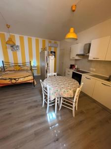 a kitchen with a table and chairs and a bed at IL PARADISO delle farfalle in Santa Maria degli Angeli