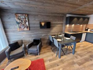 a room with a table and chairs and a kitchen at Charmant T2 près pistes, Les Gets, balcon, parking, wifi - FR-1-598-135 in Les Gets +7 photos