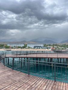 a pier on the water with buildings in the background at Апартамент,Новел отель,село Корумду in Korumdy