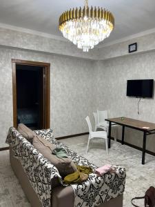 a living room with a couch and a chandelier at Апартамент,Новел отель,село Корумду in Korumdy