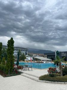 a swimming pool with tables and chairs in a resort at Апартамент,Новел отель,село Корумду in Korumdy