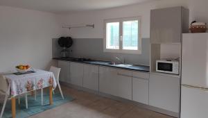 a kitchen with a table and a white refrigerator at Villa Entre Terre & Mer in Vidauban