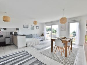 un soggiorno bianco con tavolo e divano di Appartement spacieux avec piscine, balcon, parking et wifi à Publier - FR-1-498-99 a Publier