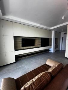 a living room with a couch and a flat screen tv at Axxis Luxury Studio in Mamaia