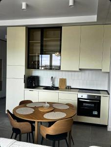 a kitchen with a table and chairs in a kitchen at Axxis Luxury Studio in Mamaia +9 photos