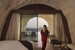 ḨanakDesert Rock Resort的站在有床的房间的女人