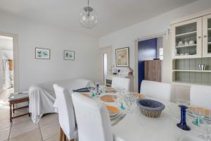 ein weißes Esszimmer mit einem weißen Tisch und Stühlen in der Unterkunft 600 m de la plage, maison pour 4 adultes 2 enfants in Tharon-Plage