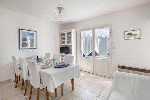 ein Esszimmer mit einem weißen Tisch und weißen Stühlen in der Unterkunft 600 m de la plage, maison pour 4 adultes 2 enfants in Tharon-Plage + 14 Fotos