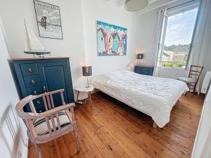 a bedroom with a bed and a chair and a window at Villa au Calme avec Jardin, Proche Plage et Commerces, Wifi et Équipements Complets - FR-1-361-117 in Jullouville-les-Pins