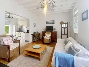 a living room with a couch and a table at Villa au Calme avec Jardin, Proche Plage et Commerces, Wifi et Équipements Complets - FR-1-361-117 in Jullouville-les-Pins