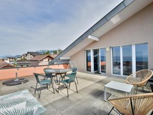 eine Terrasse mit Stühlen und einem Tisch auf einem Balkon in der Unterkunft Spacieux appartement avec terrasse, animaux admis et parking - FR-1-498-69 in Évian-les-Bains