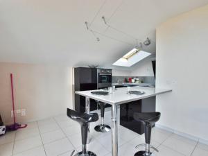 eine Küche mit einer weißen Theke und Stühlen in der Unterkunft Spacieux appartement avec terrasse, animaux admis et parking - FR-1-498-69 in Évian-les-Bains