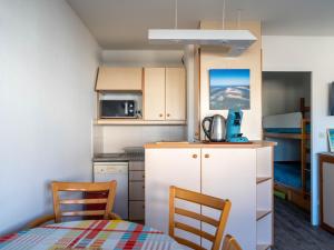 a small kitchen with a table and two chairs at Appartement Calme Proche Plage avec Parking Sécurisé et Balcon - Arcachon - FR-1-319-547 in Arcachon
