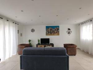 a living room with a blue couch and two chairs at gites des polders in Saint-Quentin-en-Tourmont