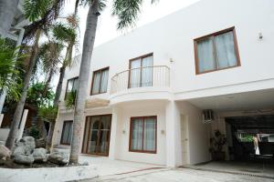 a white house with palm trees in front of it at Frania Boutique Hotel in San Juan