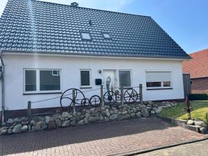 a white house with a stone wall in front of it at Zur Mühle in Varel