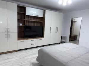 a white bedroom with a tv and a bed at Ocna Escape 4 in Ocna-Mureşului