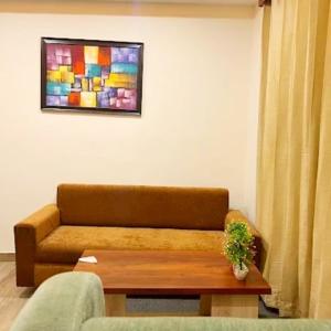 a living room with a couch and a table at Mountain Paradise in Joshīmath