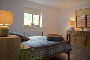 a bedroom with a bed and a dresser and a window at Auchenhill Lodge in Denny