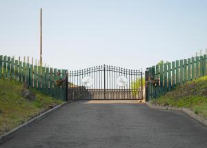 a gate to a driveway with flowers on it at Auchenhill Lodge in Denny
