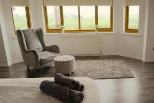 a living room with a chair and a couch at Auchenhill Lodge in Denny