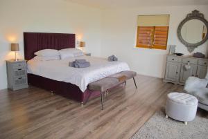 a bedroom with a bed and a chair and a mirror at Auchenhill Lodge in Denny