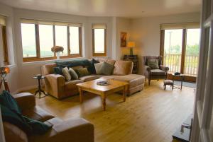 a living room with couches and a coffee table at Auchenhill Lodge in Denny