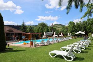 a row of white lounge chairs next to a swimming pool at Cazare la Munte cu Piscină in Bistra +37 photos