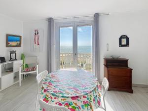 a dining room with a table and a view of the ocean at Appartement avec balcon, jardin, et accès plage - FR-1-361-492 in Jullouville-les-Pins