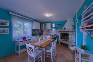 a blue kitchen with a table and a fireplace at Villa Biankura in Blato